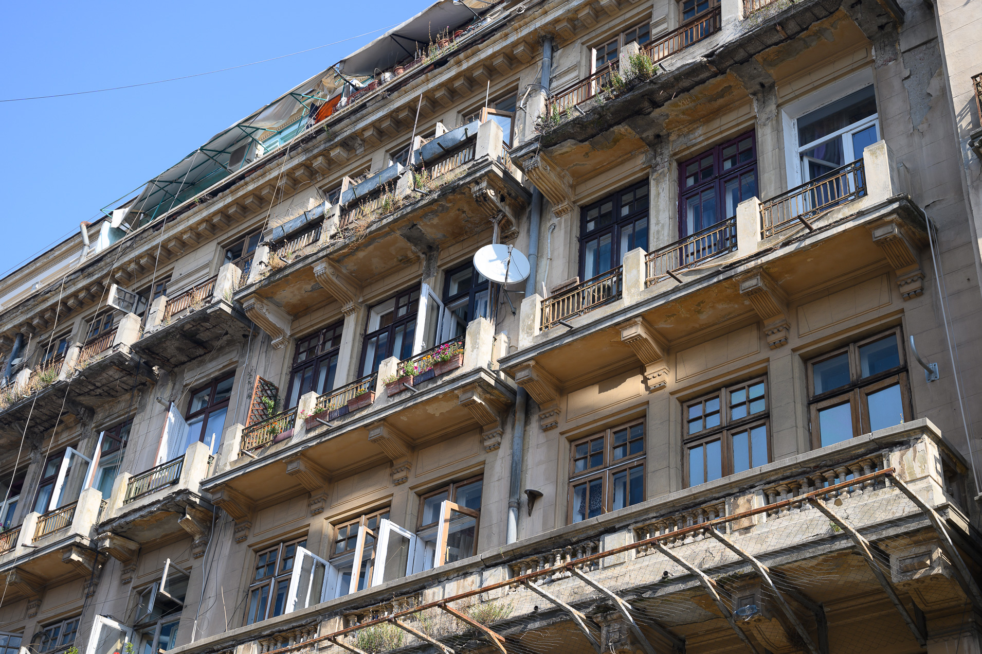 Neglect and decay after the 1989 coup is evident.  Squatters with a few modern gadgets occupy this downtown structure. ...